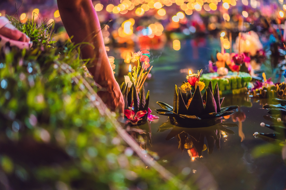 A person releasing a Krathong into the water in Phuket 