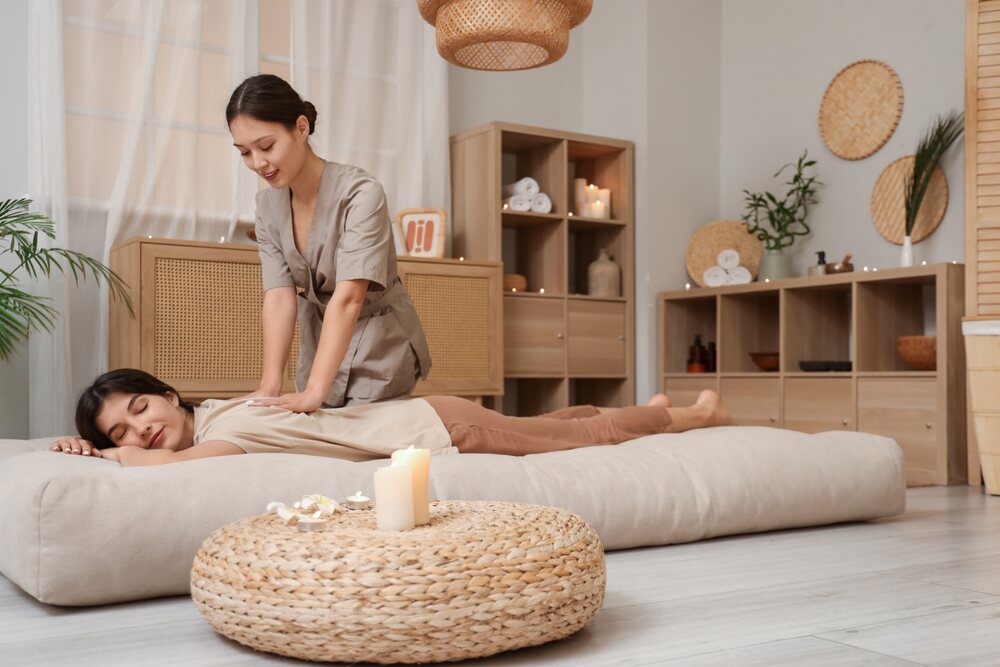 A woman enjoying a Thai massage at a spa in Phuket.